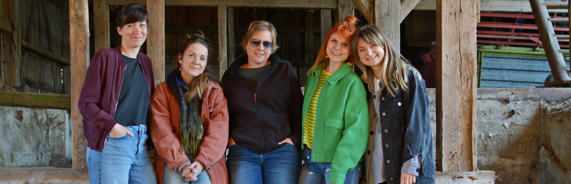 Die fünf Frauen des SafeSpace-Teams stehen zusammen in einer Scheune