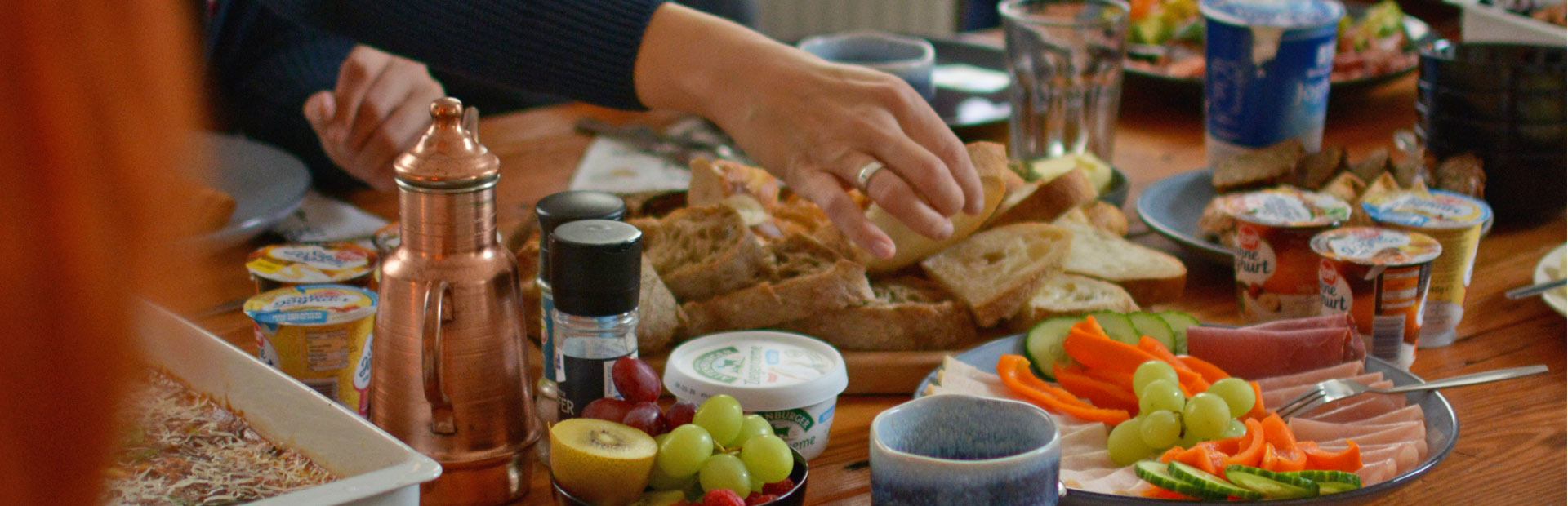 Reichhaltiger Frühstückstisch mit frischem Obst, Brot und Aufschnitt